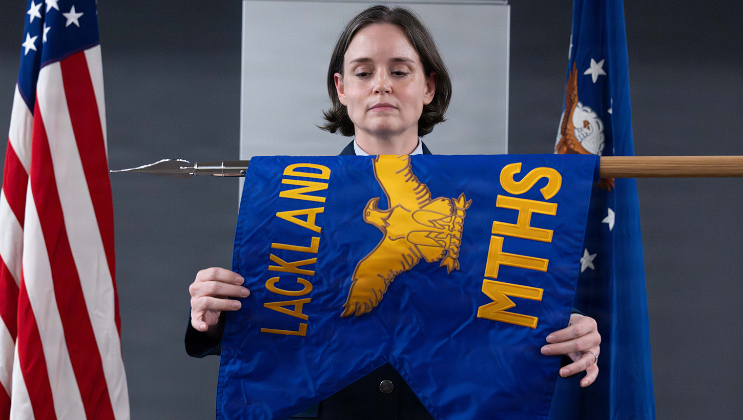 U.S. Air Force Col. Shawn Garcia, commander of the Lackland Medical Group, unfurls the newly activated Lackland Mental Health Squadron guidon during an activation ceremony