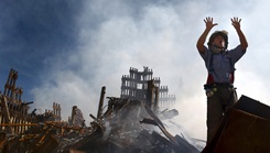 Photo of Firefighter atop of 9/11 rubble