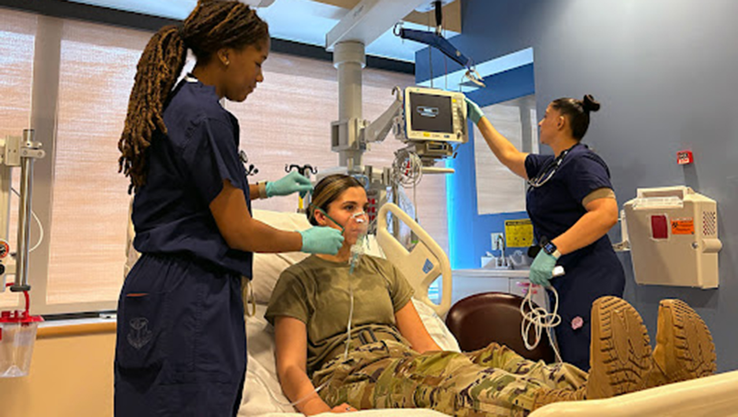 Airman 1st Class Kennedy Goodwin (left) and Airman 1st Class Juana Conde (right) simulate an emergency nebulizer treatment