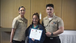 Navy Medicine Training Support Center (NMTSC), Detachment Camp Lejeune held a ceremony on July 23, 2026, honoring its latest student from the Surgical Technology Program (Phase II) graduates Hospital Corpsman Second Class Emely Betancourt (left) and Hospital Corpsman Second Class Caue Uemura (right) present civilian surgical technologist Azucena Naval with Naval Medical Center Lejeune the "Golden Scalpel Award."