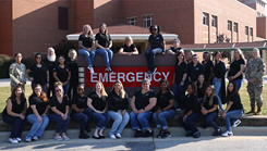 Womack Army Medical Center forensic health care examiners pose for a picture around the emergency sign in front of the WAMC emergency room entrance, August 29, 2024.