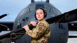 Senior Airman Kaylee Hess, an aeromedical evacuation technician with the 187th Aeromedical Evacuation Squadron, 153rd Airlift Wing, Wyoming Air National Guard, stands in front of a C-130 Hercules aircraft