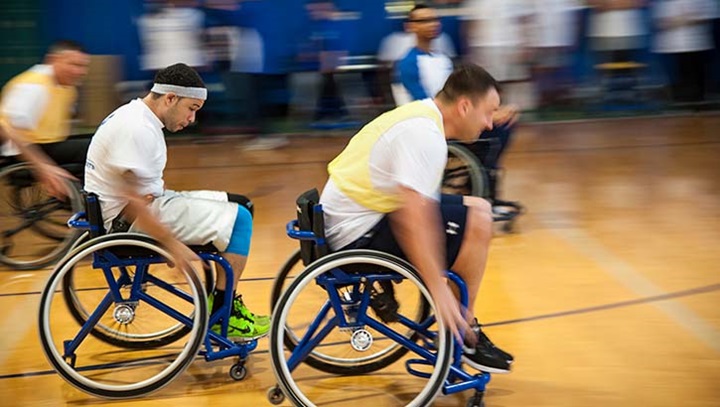 Image of Airmen race for a loose ball during an Air Force Wounded Warrior basketball game .