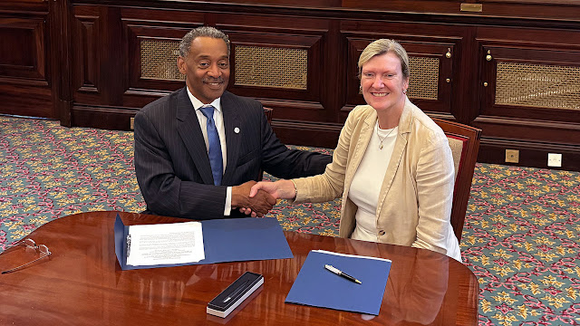 USU President Dr. Jonathan Woodson and Air Marshal Clare Walton, Chief of Defence Medical for the UK, shake hands after signing a Memorandum of Understanding expanding military medical collaboration between the two nations, July 2, in London. (Photo credit: MOD Crown Copyright)