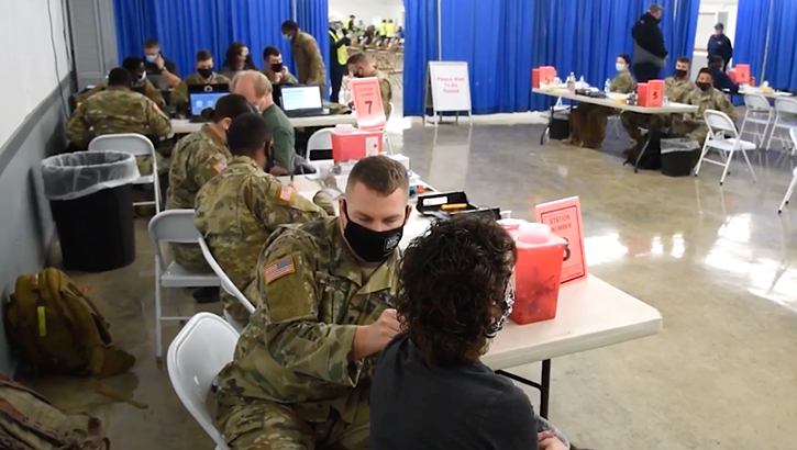 Military personnel giving the flu shot
